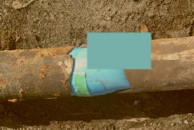 A cutaway of a rusted host pipe with a blue liner seated inside it.